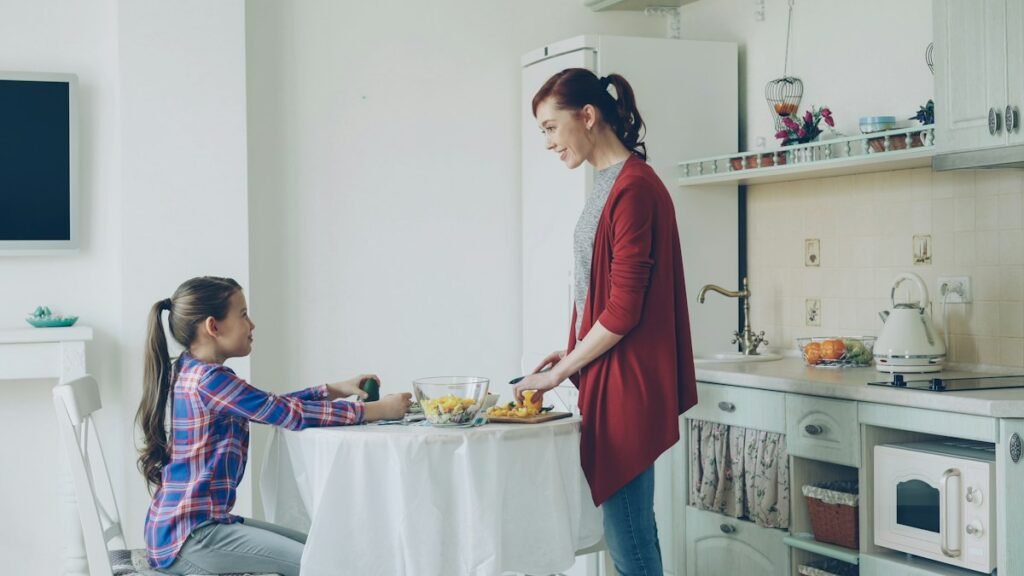 Mother serving her young daughter breakfast at the table